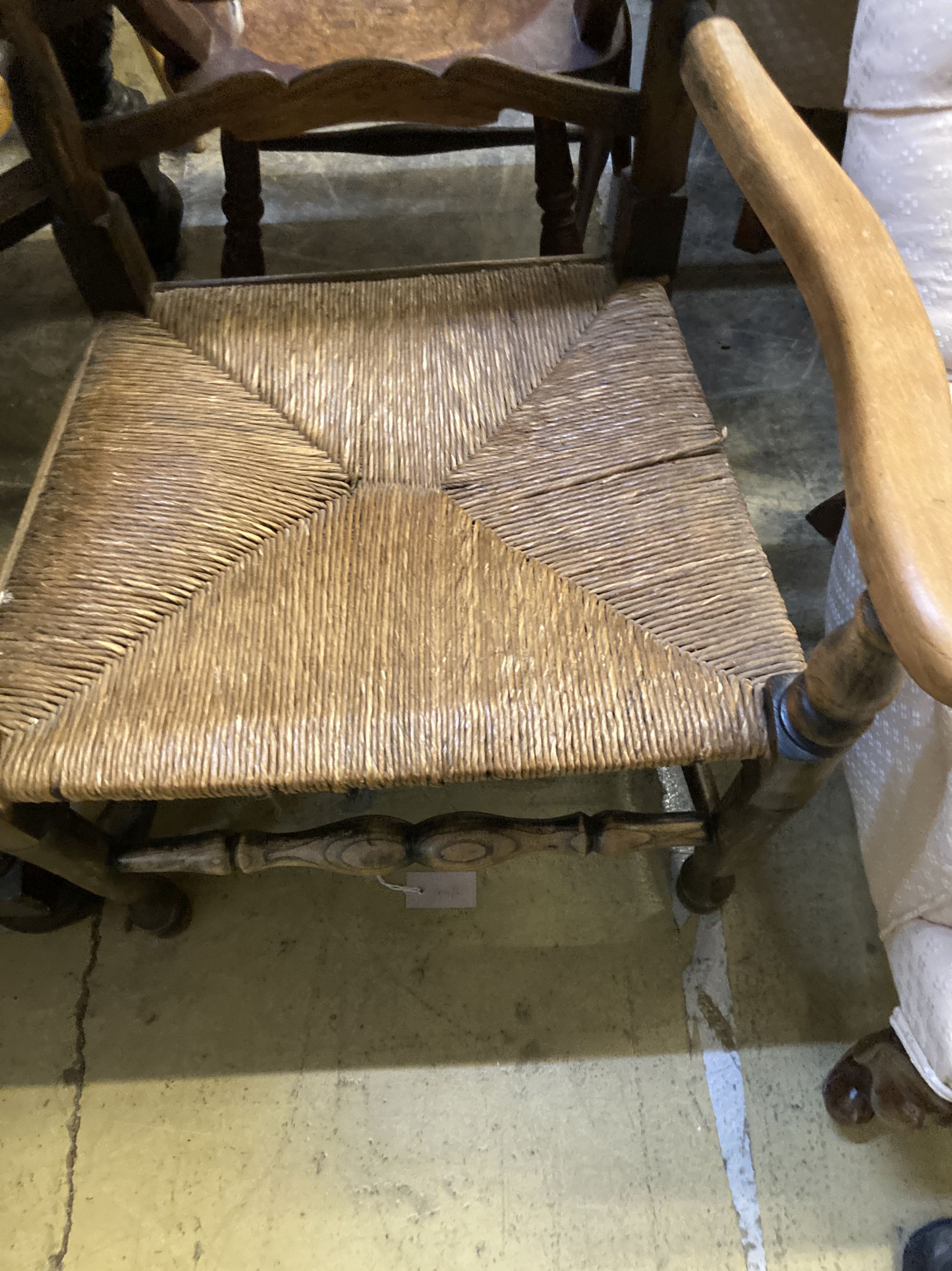A 19th century ash and beech ladderback elbow chair and a spindle back elbow chair (2)